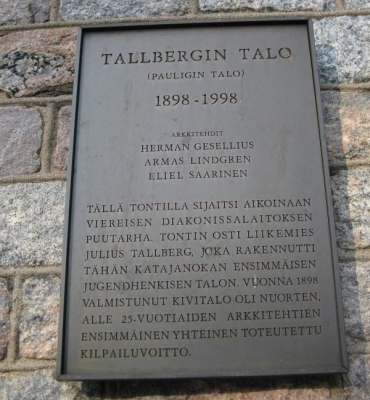 Tallbergin talon kyltti. Talon suunnitteli kolme nuorta arkkitehtia.