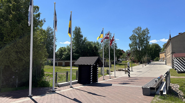 Viron Valgasta otettu kuva Latvian Valkan suuntaan. Viron ja Latvian lippujen lisäksi saloissa on myös Ukrainan liput.